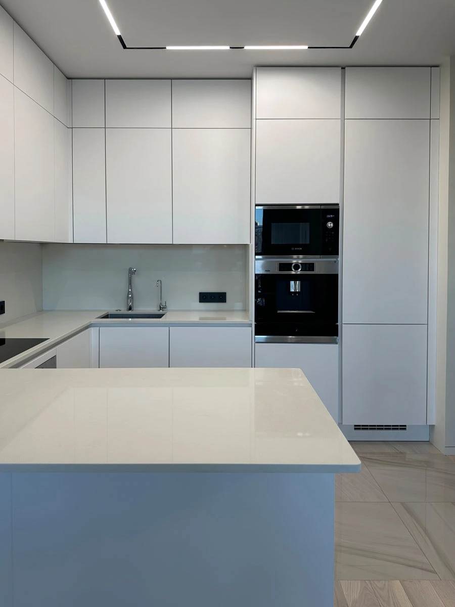 Белая п-образня немецкая кухня. Фасады без ручек и отпечатков пальцев