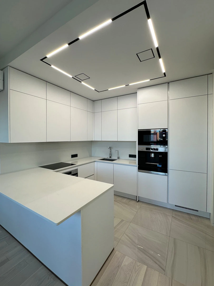 Белая п-образня немецкая кухня. Фасады без ручек и отпечатков пальцев