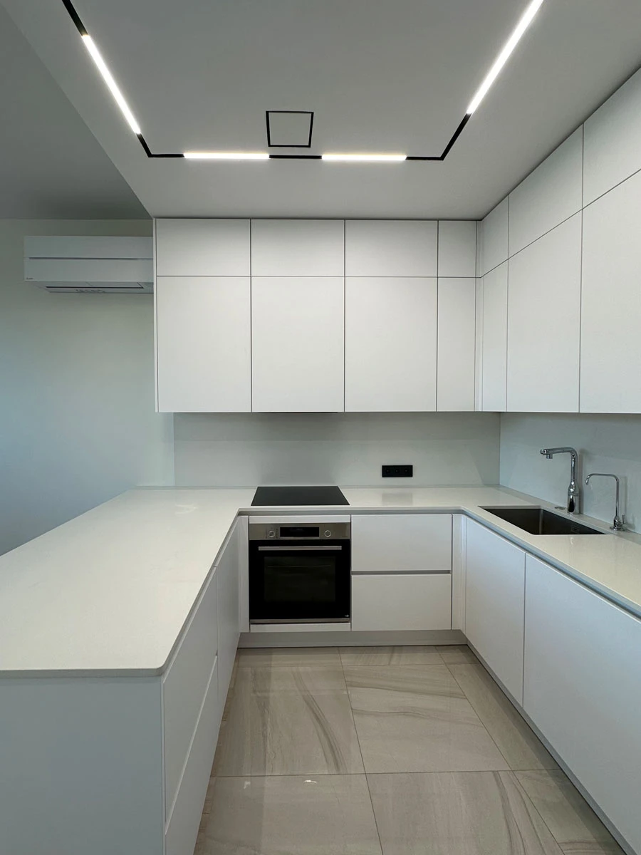 Белая п-образня немецкая кухня. Фасады без ручек и отпечатков пальцев