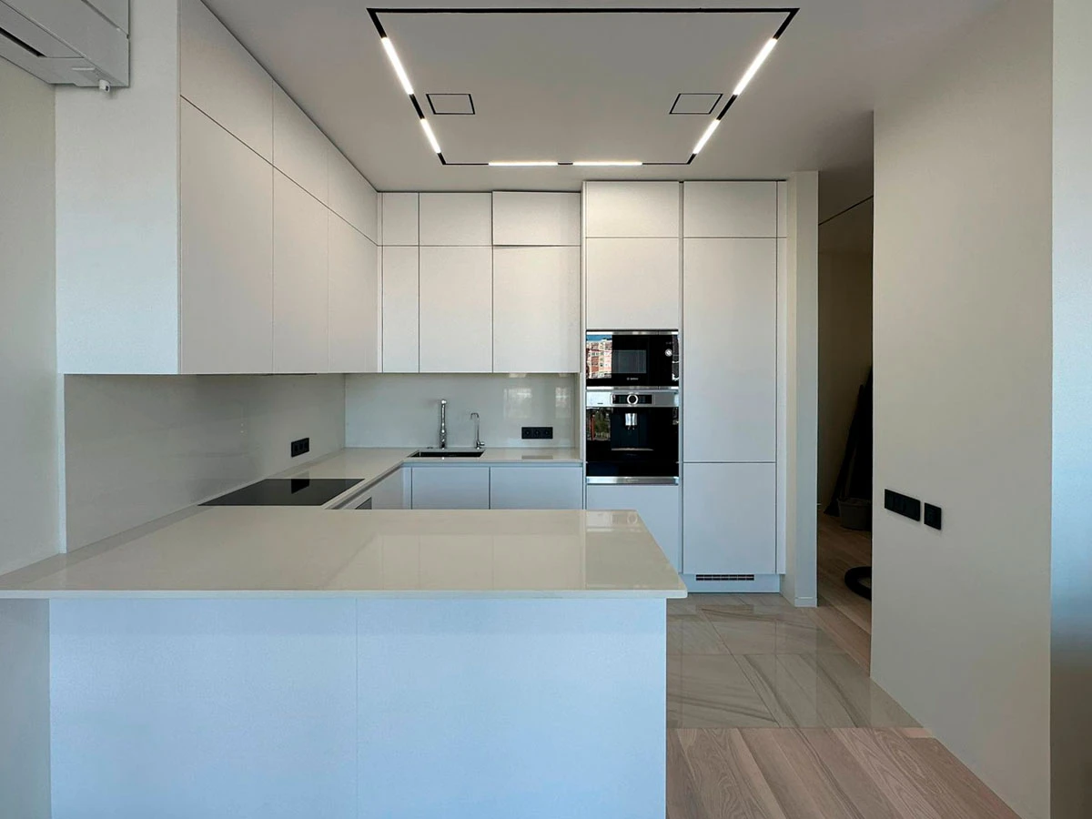 Белая п-образня немецкая кухня. Фасады без ручек и отпечатков пальцев