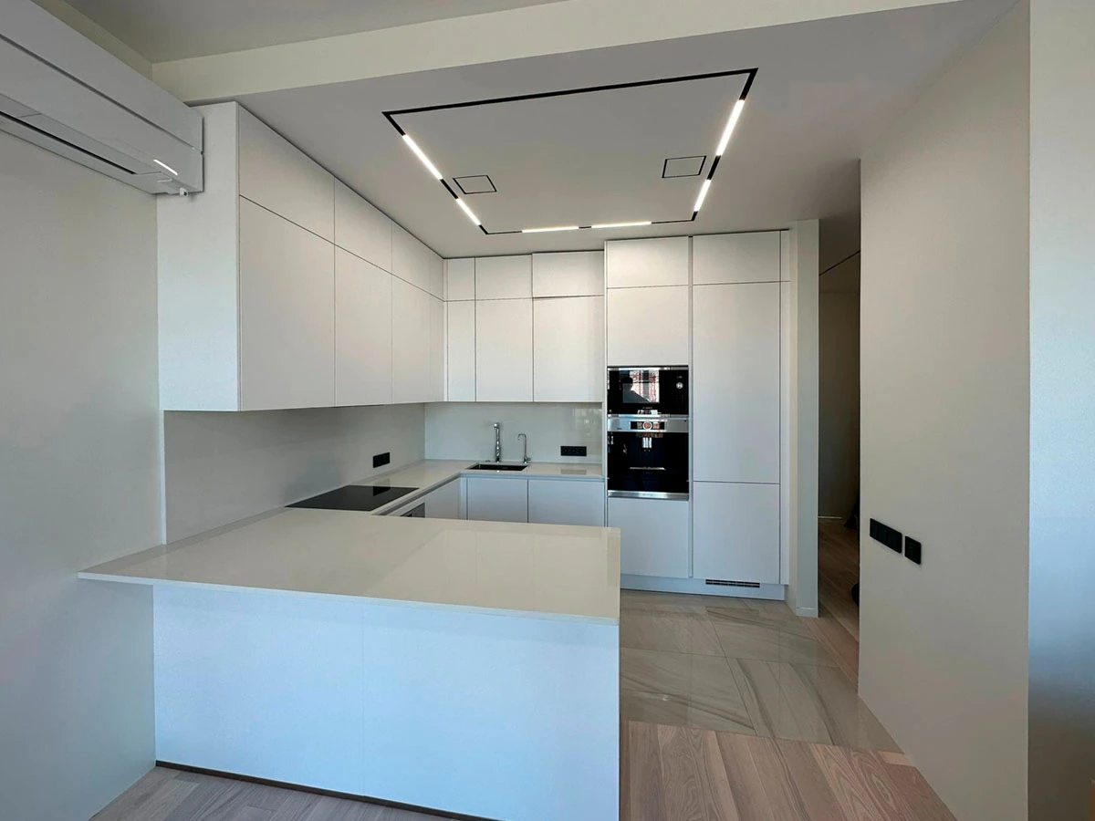 Белая п-образня немецкая кухня. Фасады без ручек и отпечатков пальцев