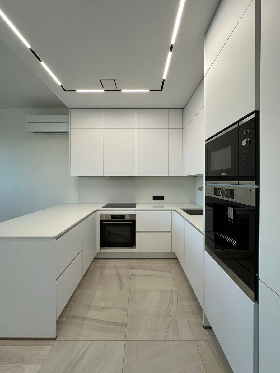 Белая п-образня немецкая кухня. Фасады без ручек и отпечатков пальцев